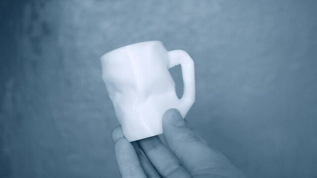 The person holds on his hands and view white object created on 3d printe