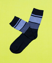 A pair of black men's socks on a yellow background