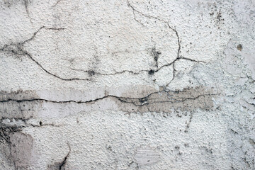A wall with white cracked plaster. Texture, surface, background.