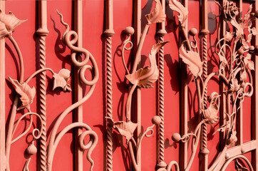 Beautiful forged flowers on a red metal gate