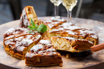 Authentic sponge cake with raisins, cinnamon and apples. Morning atmospheric lighting, fashionable trendy spot soft focus. Preparation for design creative menu. Culinary pastries.