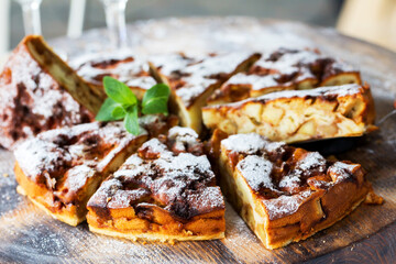 Authentic sponge cake with raisins, cinnamon and apples. Morning atmospheric lighting, fashionable trendy spot soft focus. Preparation for design creative menu. Culinary pastries.