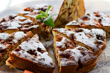 Authentic sponge cake with raisins, cinnamon and apples. Morning atmospheric lighting, fashionable trendy spot soft focus. Preparation for design creative menu. Culinary pastries.