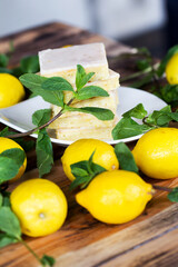 Authentic Shortcake Cake, a lot of fresh yellow lemons and mint. Morning atmospheric lighting, fashionable trendy spot soft focus. Preparation for design creative menu.