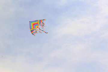 papalote multicolor volando entre las nubes en lo mas alto del cielo