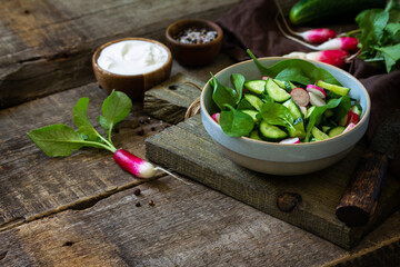 Healthy vegan food. Vegetarian vegetable salad of spinach, radish and fresh cucumber. Copy space.