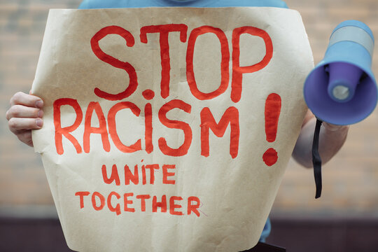 men hands holding a poster with the inscription stop racism unite together