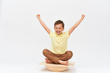 small boy is sitting on a special simulator for training vestibular apparatus.