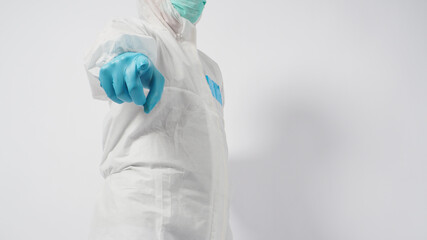 Male asian doctor  in PPE suite or Personal Protective Equipment and medical face mask to protect virus doing point hand sign on white background.