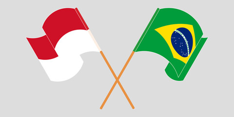 Crossed and waving flags of Indonesia and Brazil