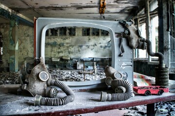 Soviet-era gas masks are hung up on a weathered TV screen in an abandoned building in Pripyat,...