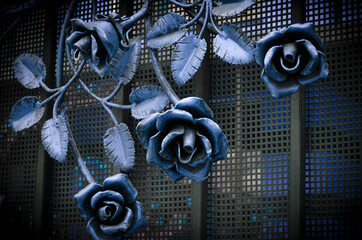 Beautiful forged blue roses on a metal fence
