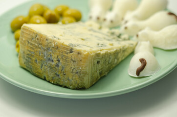 Full fat soft blue veined cheese with olives and snacks in the shape of mice