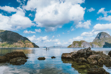 Fototapeta na wymiar Palawan, Philippines. Seascape of El Nido bay, with white clouds, ocean reflection and Cadlao island in background