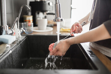 Young woman wash dishes and glass at kitchen