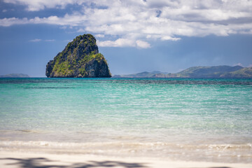El Nido, Palawan, Philippines. Tropical jutted rocky island in open ocean and cloudscape
