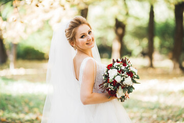 Beauty portrait of bride wearing fashion wedding dress with feathers with luxury delight make-up and hairstyle