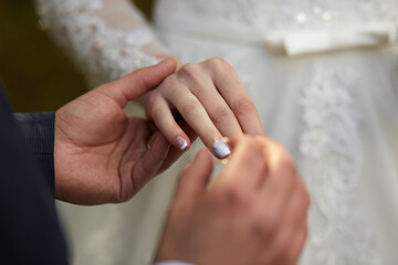 Obraz na płótnie Canvas newlyweds exchange rings at wedding
