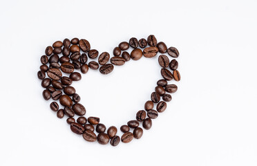 Coffee beans laid out in the shape of a heart on a white background