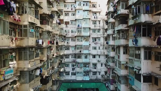 Aerial: Drone flying backward from residential building in city - Hong Kong, China