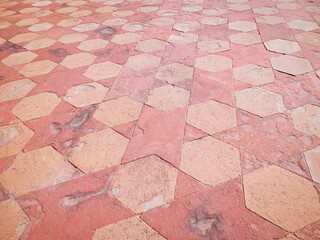 Detail of the geometric floor tiling outside the Taj Mahal. Stars and hexagonal shapes in warm pink...