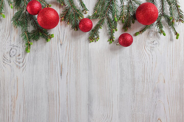 Christmas Border - tree branches with bright red shiny  balls on a wooden background. Christmas wallpaper. Flat lay, top view.