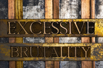 Photo of real authentic typeset letters forming Excessive Brutality of text on vintage textured...