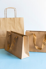 Zero waste shopping concept, kraft brown paper bags on blue white background. 