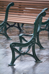 Details of park benches before assembling in public park, lots of wooden benches during rain outside, selective focus
