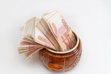 Russian banknotes of five thousand rubles in large quantities in a ceramic pot