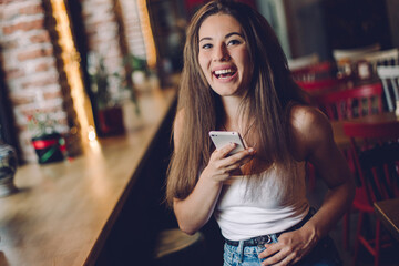 Woman using phone  in a cafe.