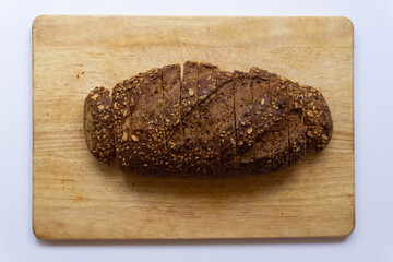 Entire integral bread on a wooden table. Cut on slices. Healthy integral bread concept. Healthy food. Self care.