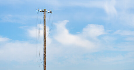 defekter Strommast mit abgeschnittenen Leitungen vor blauem Himmel mit ausreichend Textfreiraum