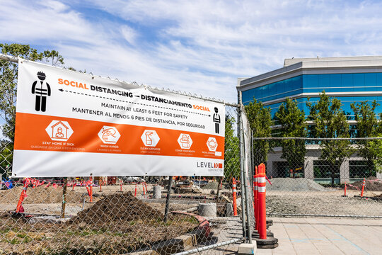 May 10, 2020 Sunnyvale / CA / USA - Social Distancing rules meant to protect against the transmission of COVID-19, in English and Spanish, displayed at the entrance to a commercial construction site;
