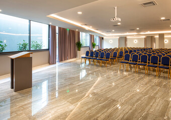 Modern auditorium interior with lecturer desk and rows of vintage chairs in luxury training center....