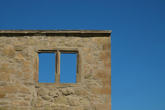 Brown window in a brick castle with a blue sky, two thirds normally. Germany.
