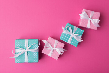 Gift boxes with white bows over pink background with copy space