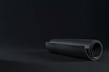yoga mat for practicing yoga positions, sport workout fitness exercise. dark background. copy space