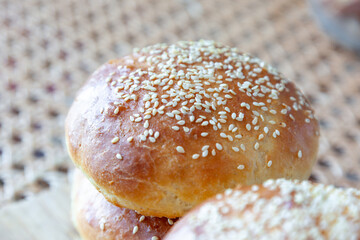 Top of burger bun with sesame seeds on rattan table 