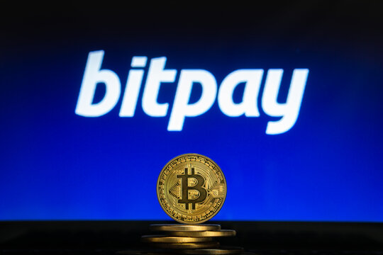 Bitcoin on a stack of coins with Bitpay logo on a laptop screen. Cryptocurrency and blockchain adoption concept. Slovenia, Ljubljana - 02 24 2019