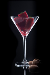 red cStrawberry Sorbet with crispy cookies on black background in a martini glass