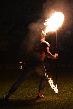 Man Spitting Fire At A Party.