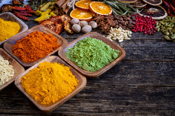 Many colorful spices, herbs and dried fruits on the wooden rustic table