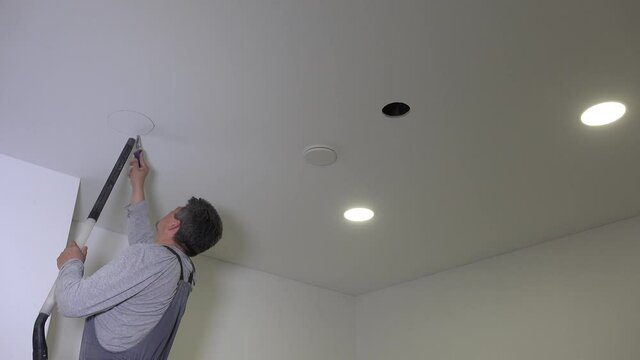 builder man saw round hole in plasterboard ceiling