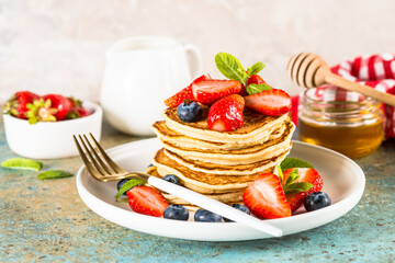 Pancakes with fresh berries and honey.
