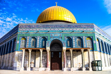 Frontal view of the Dome of the Rock with its vibrant colored mosaics on a sunny day with bright blue sky. Temple Mount, old Jerusalem, Israel.