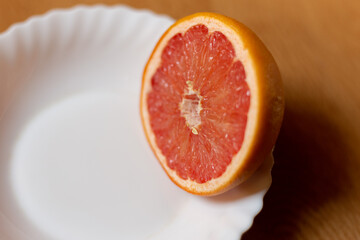 Naklejka na ściany i meble Somewhat old and dried grapefruit cut in half on white saucer.