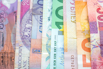 A rainbow of banknotes of different world currencies, including Euro notes, Australian Dollars, Israeli Shekels, South African Rand and Polish Złoty. 