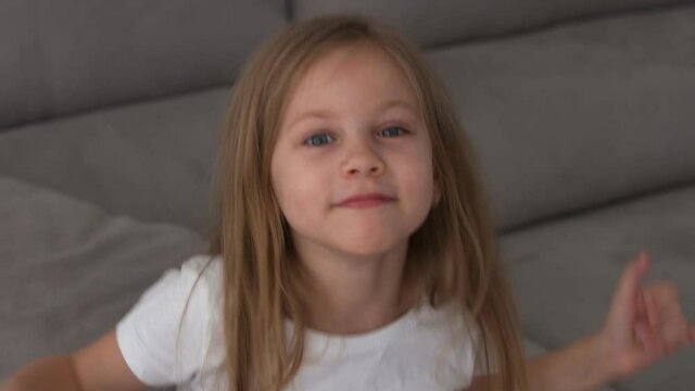 happy six year old girl fooling around and making a face and showing likes. High quality 4k footage