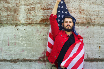 bearded man with glasses  waving american USA flag against  gray concrete wall